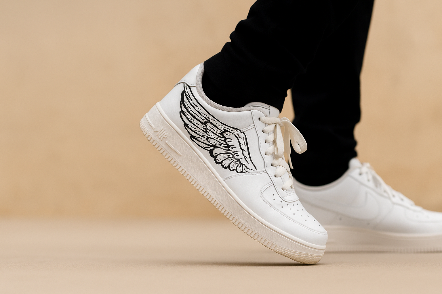White sneakers with wing design on a beige background
