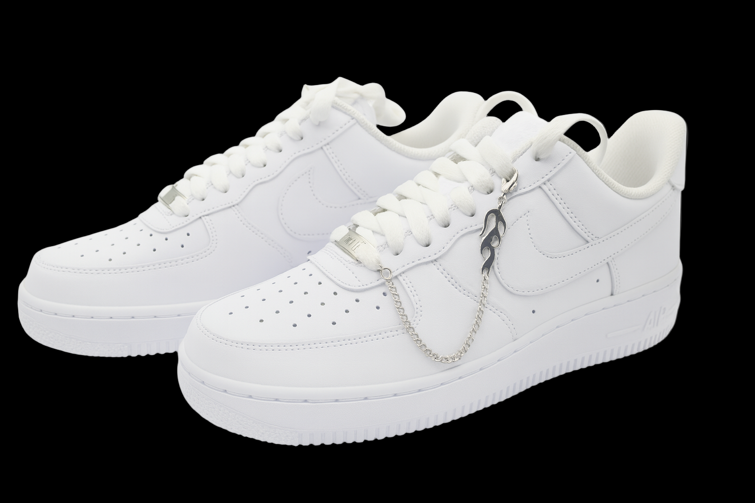 White sneakers with a chain detail on a black background